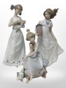 A Lladró figure of a girl and a dog, No. 5466, and two Nao figures of girls.