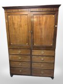 A mahogany double-door wardrobe in the form of a Georgian linen press with faux cupboards and
