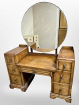 A 1930s oak mirror-back sunk-centre dressing table, 108cm wide x 49cm deep x 145cm high.