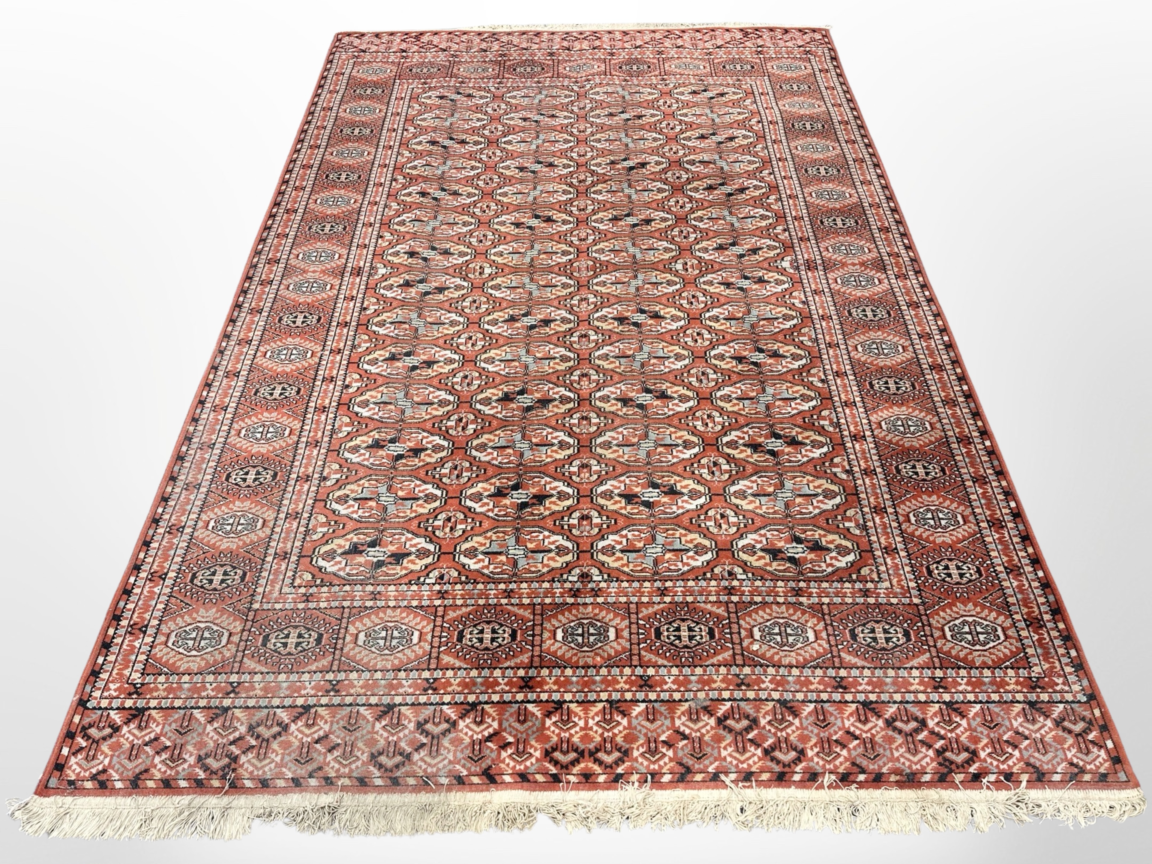 A machine-made Afghan-design carpet,