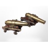 A miniature pair of brass cannons on wooden carriages, length 17cm.