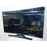 A Samsung 55-inch curved LCD TV with lead and remote.