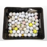 A box containing a large quantity of golf balls.