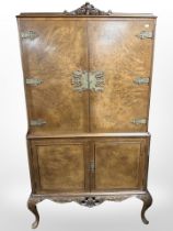 A 20th-century burr walnut brass-mounted drinks cabinet on cabriole legs,