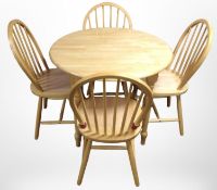 A contemporary pine circular kitchen table, diameter 90cm, and a set of four spindle-back chairs.