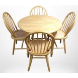 A contemporary pine circular kitchen table, diameter 90cm, and a set of four spindle-back chairs.