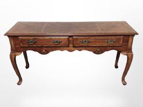 A reproduction yew wood dresser base in the Georgian style, raised on cabriole legs,