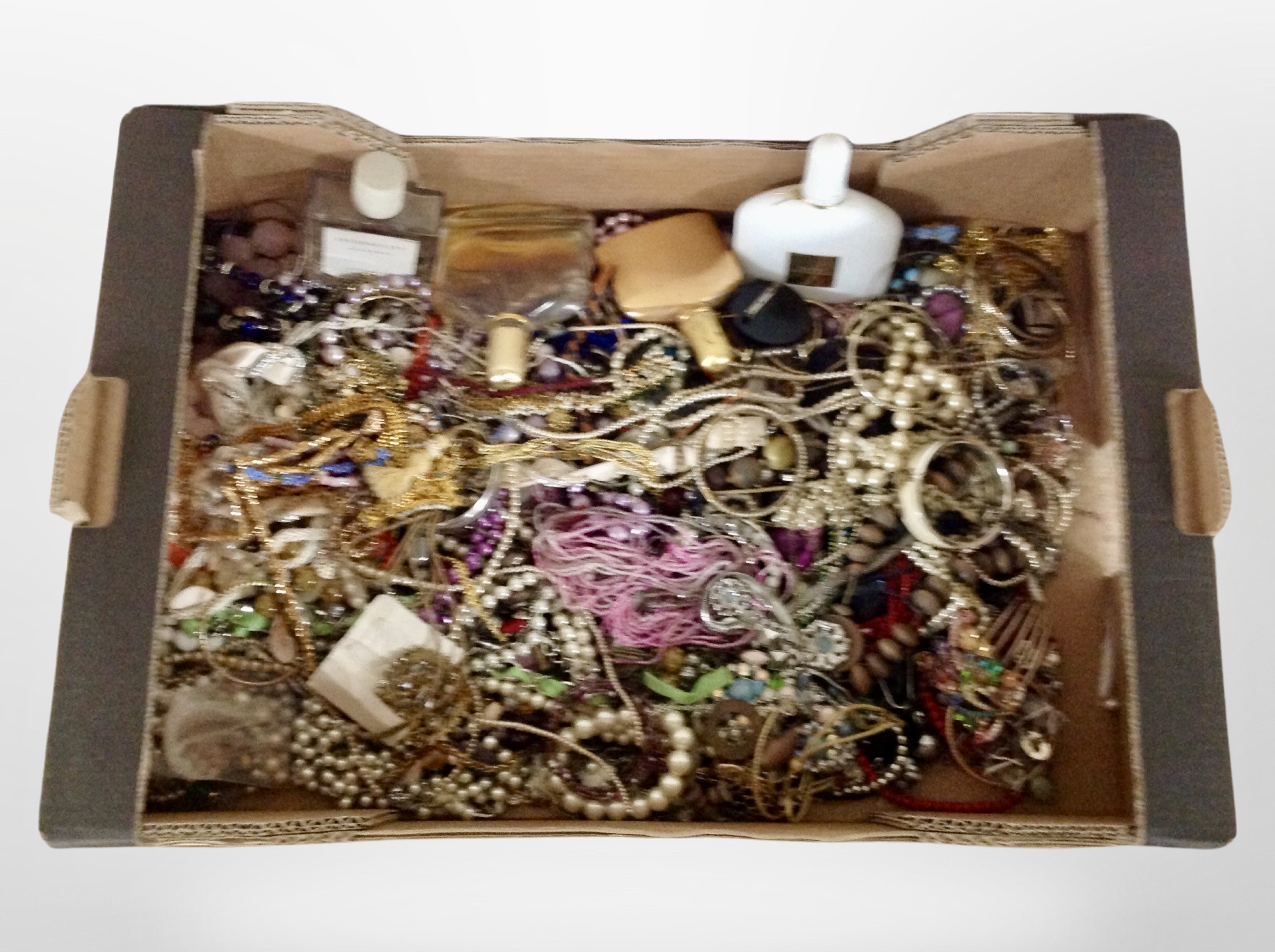 A box of a large quantity of costume necklaces, bangles, faux pearls, perfume bottles, etc.