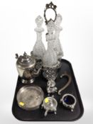 An ornate 19th-century silver-plated bottle cruet containing a set of three cut-glass decanters