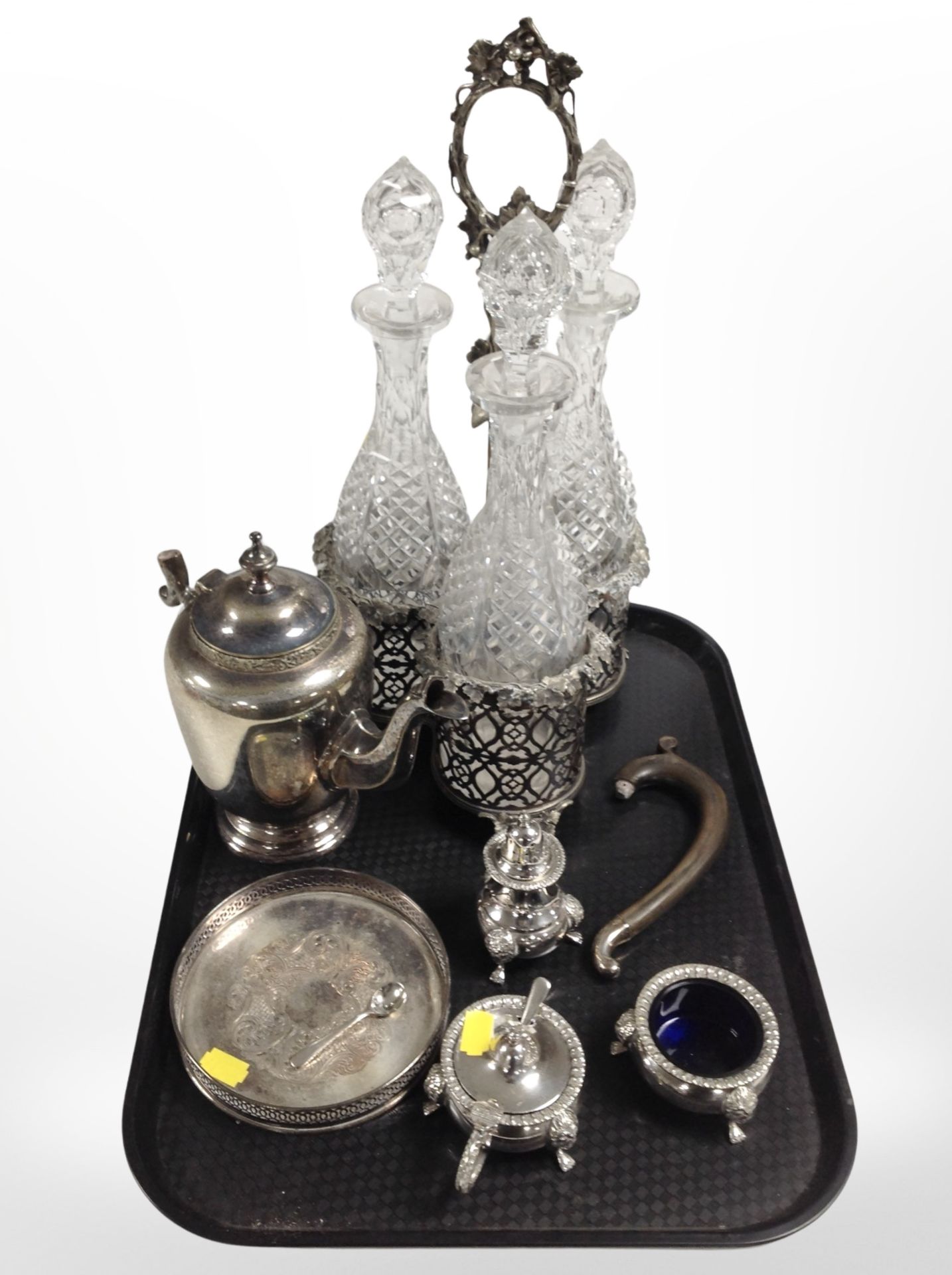 An ornate 19th-century silver-plated bottle cruet containing a set of three cut-glass decanters