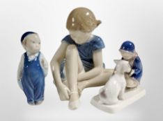 A Royal Copenhagen figure of a girl putting on ballet slippers, and two further figures,