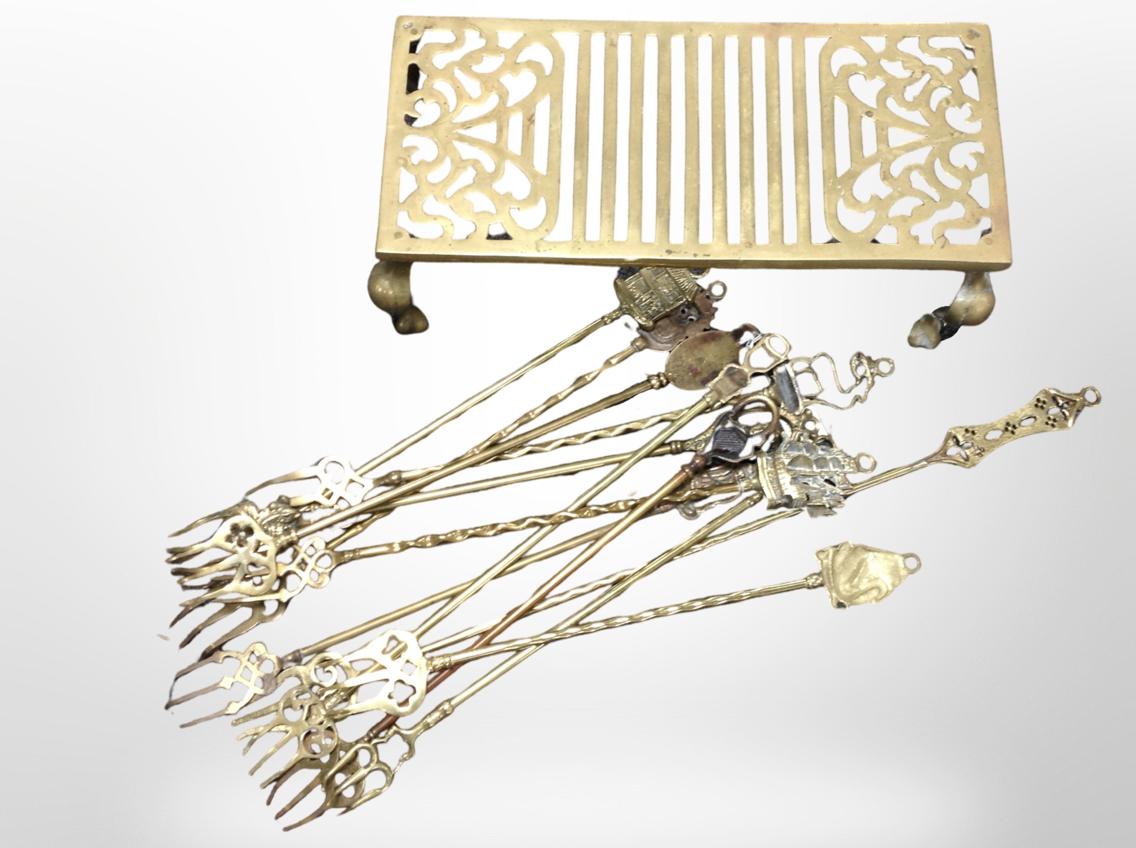 A 19th-century brass footman and a group of toasting forks.