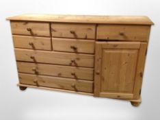 A contemporary pine sideboard fitted eight drawers and a further cupboard,