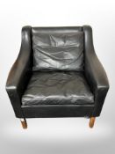 A 20th century Danish black stitched leather armchair on teak legs