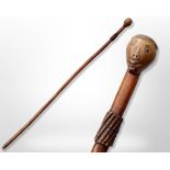 An early 20th-century South African chief's carved hardwood staff with figural pommel, length 90cm.