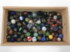 A pine crate containing vintage glass marbles,