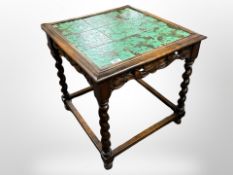 A Continental carved beech occasional table with tiled top,