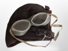 A 20th-century pilot's leather flight cap and pair of goggles.
