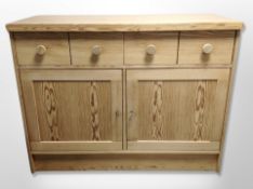 A contemporary pine sideboard fitted cupboards and drawers,