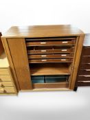 A 20th century Danish teak and pine tambour fronted office cabinet with fitted drawers,