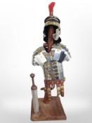 A miniature Roman suit of armour on hardwood stand, height 63cm.