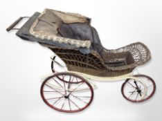 An early 20th century painted wrought metal and wicker pram