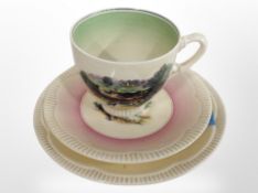 A Clarice Cliff Newport Pottery teacup and two graduated saucers decorated with landscapes.