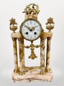 A 19th century French peach marble and gilt metal portico mantel clock, striking on a bell,