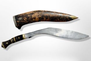 A large kukri knife in leather sheath, length 63cm.