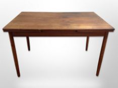 A Danish teak pull-out extending dining table,