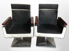 A pair of barber's rise and fall swivel armchairs on chrome supports,