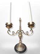 A contemporary heavy cast brass twin-branch candelabrum on socle,