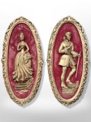 A pair of gilded chalk plaques depicting figures in 18th century dress,