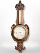 A heavily carved oak barometer with silvered dial, signed H Manley, Leeds,