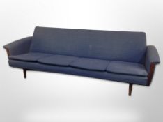 A 20th century teak framed four seater settee in blue upholstery,