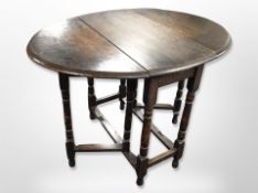 An Edwardian oak drop leaf table and six carved oak and studded brown leather dining chairs
