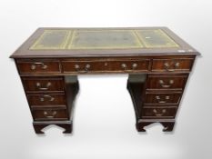 A reproduction mahogany twin pedestal writing desk with tooled leather top,