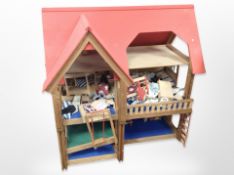 A pine and ply wood doll's house containing a quantity of dolls house furniture etc ,