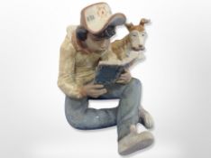 A Lladro matt glazed figure of a boy reading Tom Sawyer, no.