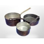 Three copper cooking pans with cast iron and brass handles,