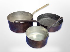 Three copper cooking pans with cast iron and brass handles,