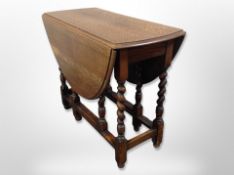 An early 20th century oak barley twist oval gateleg table,
