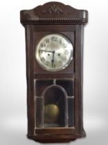 An early 20th century Continental oak eight day wall clock,
