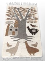 A pictorial Kilim rug depicting stylized birds beneath a tree,