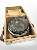 A large military compass in wooden box