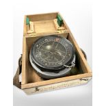 A large military compass in wooden box