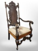 An early 20th century continental heavily carved beech armchair with tapestry seat,