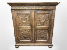 A 19th century Continental carved oak cabinet, on bun feet,