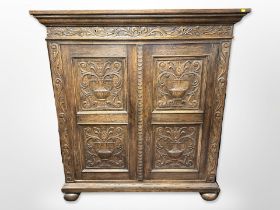 A 19th century Continental carved oak cabinet, on bun feet,