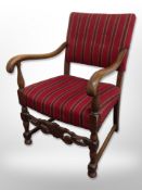 A continental carved oak armchair in striped upholstery,